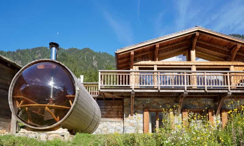a chalet in the mountain with an outdoor sauna