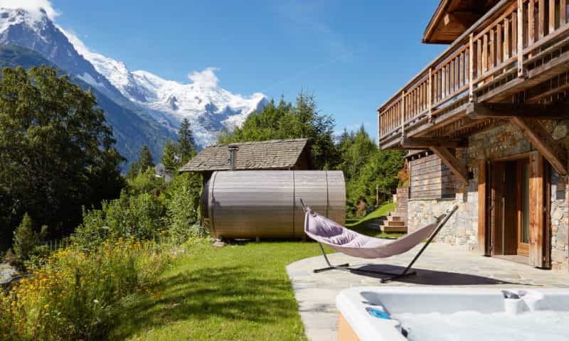 an outdoor sauna and hammock in the mountain
