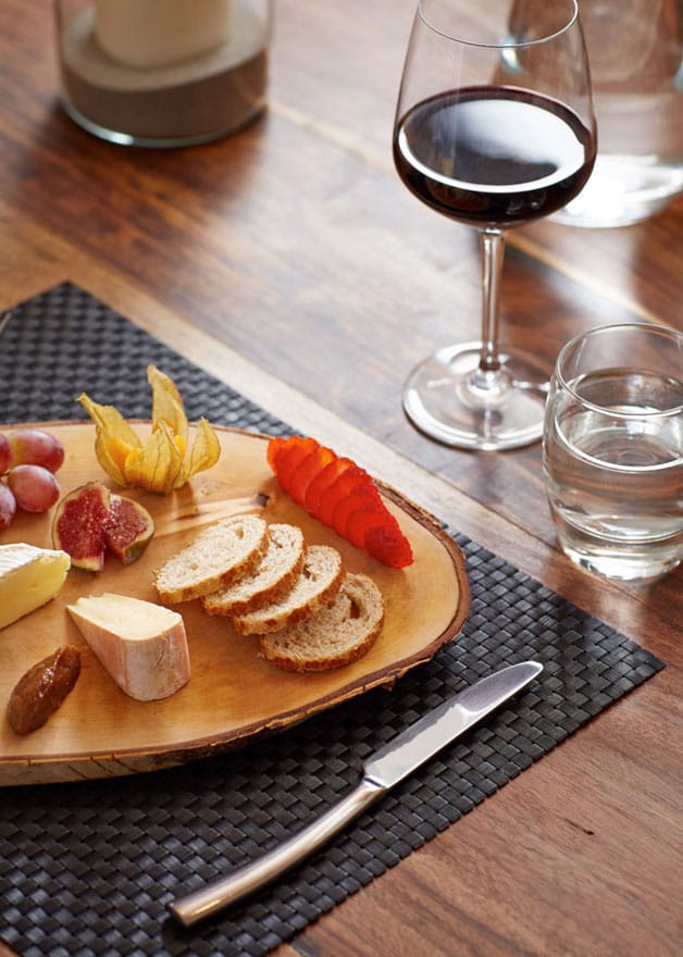 image of a cheeseboard and a glass of wine