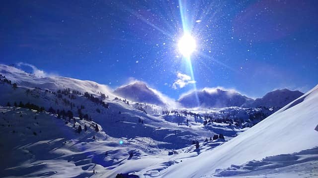 image of sun blazing down on snow resort