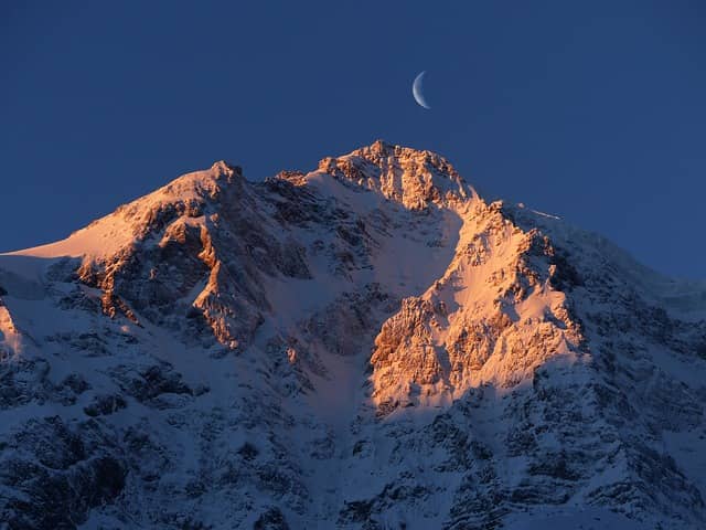 image of moon behind a mountain